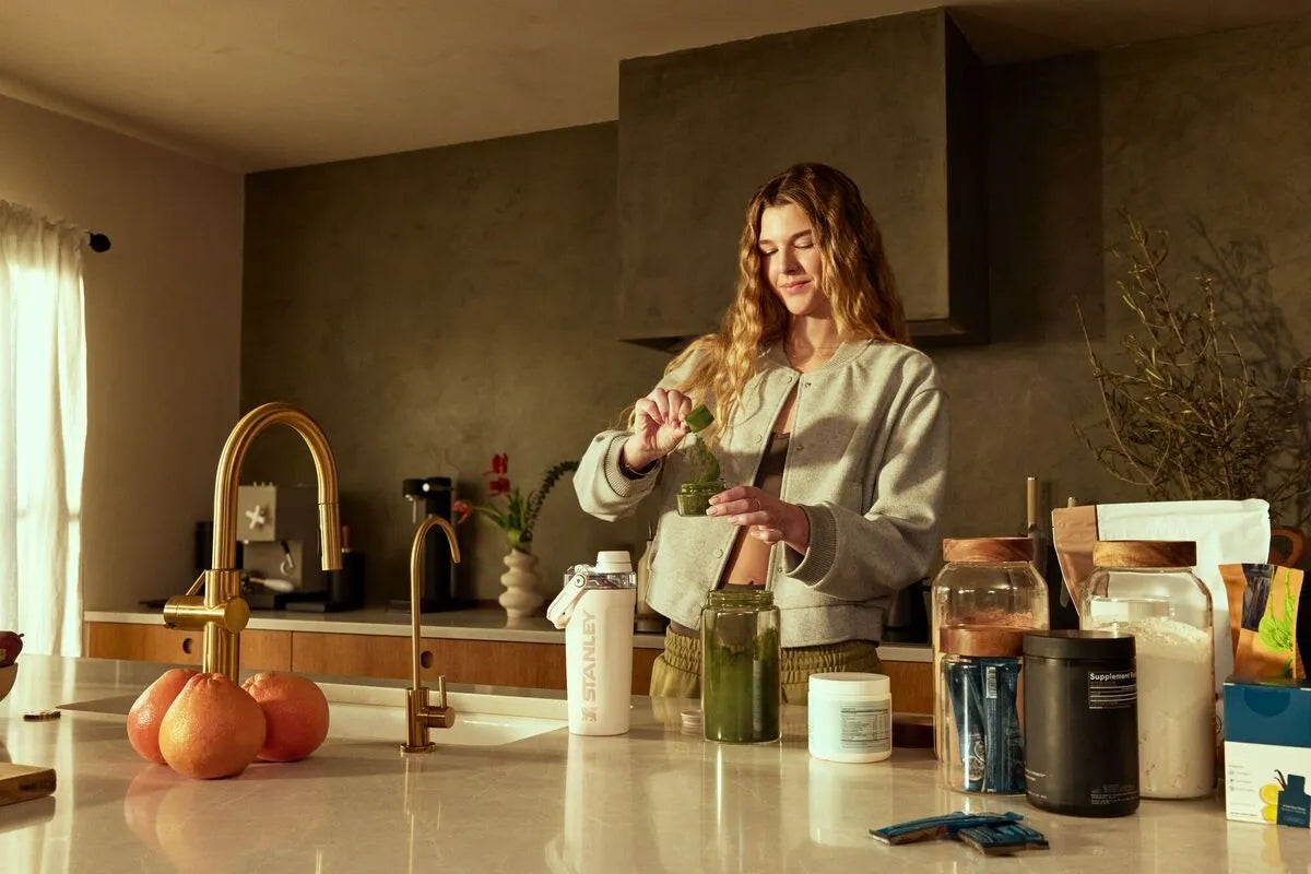 Uma mulher preparando receitas de pré-treino no Vitalize Shaker.