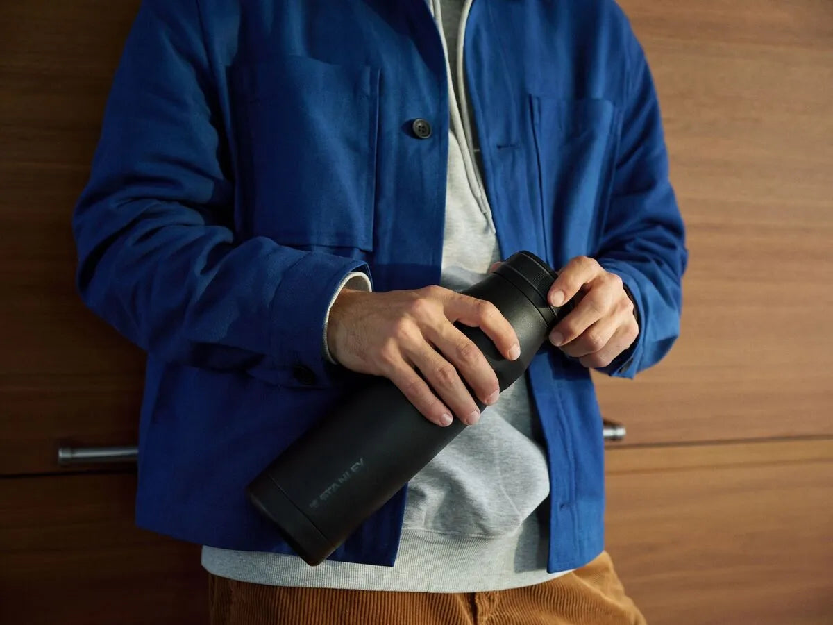 Um homem segurando a nova garrafa Stanley Twist Flip e mantendo a hidratação em dia.