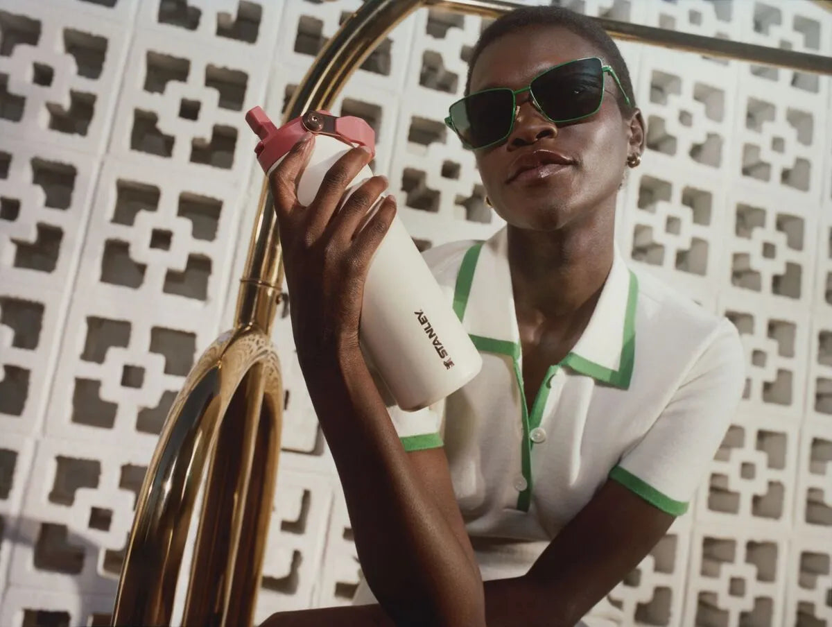 Uma mulher usando a garrafa Stanley Flip Straw após entender se ela era melhor do que a Stanley Quick Flip para o dia a dia.