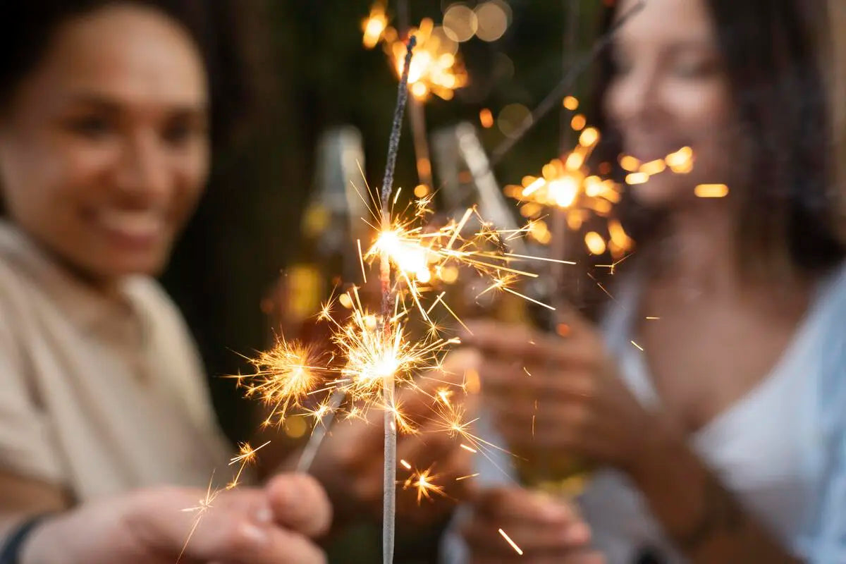 Amigos segurando velas de estrela para celebrar o réveillon.