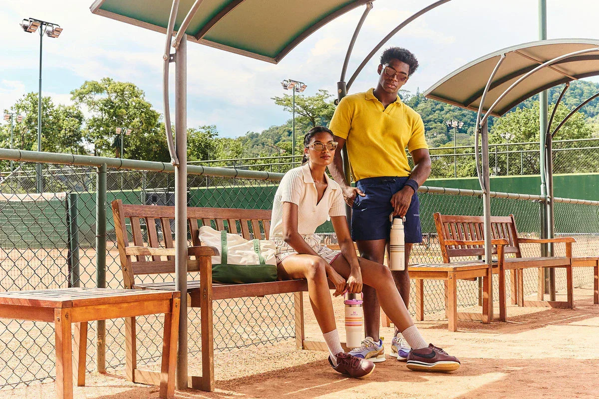 Duas pessoas segurando e usando as novas garrafas da coleção Varsity Stanley.