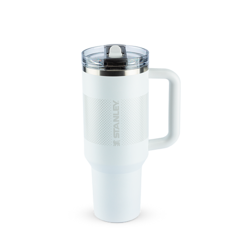 Caneca térmica Stanley branca, com alça robusta e tampa com bico articulado. Possui textura perfurada e o nome 